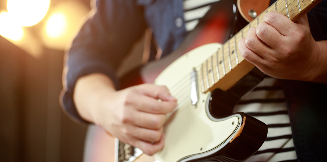 Close up of hands playing a guitar